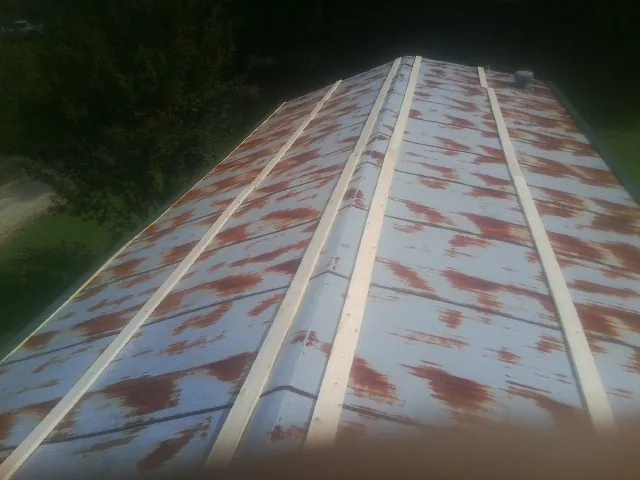 Rusted metal roof panels with new wood purlins before replacement — Storm Damage Roof Repair in Bend by Roofing Brothers