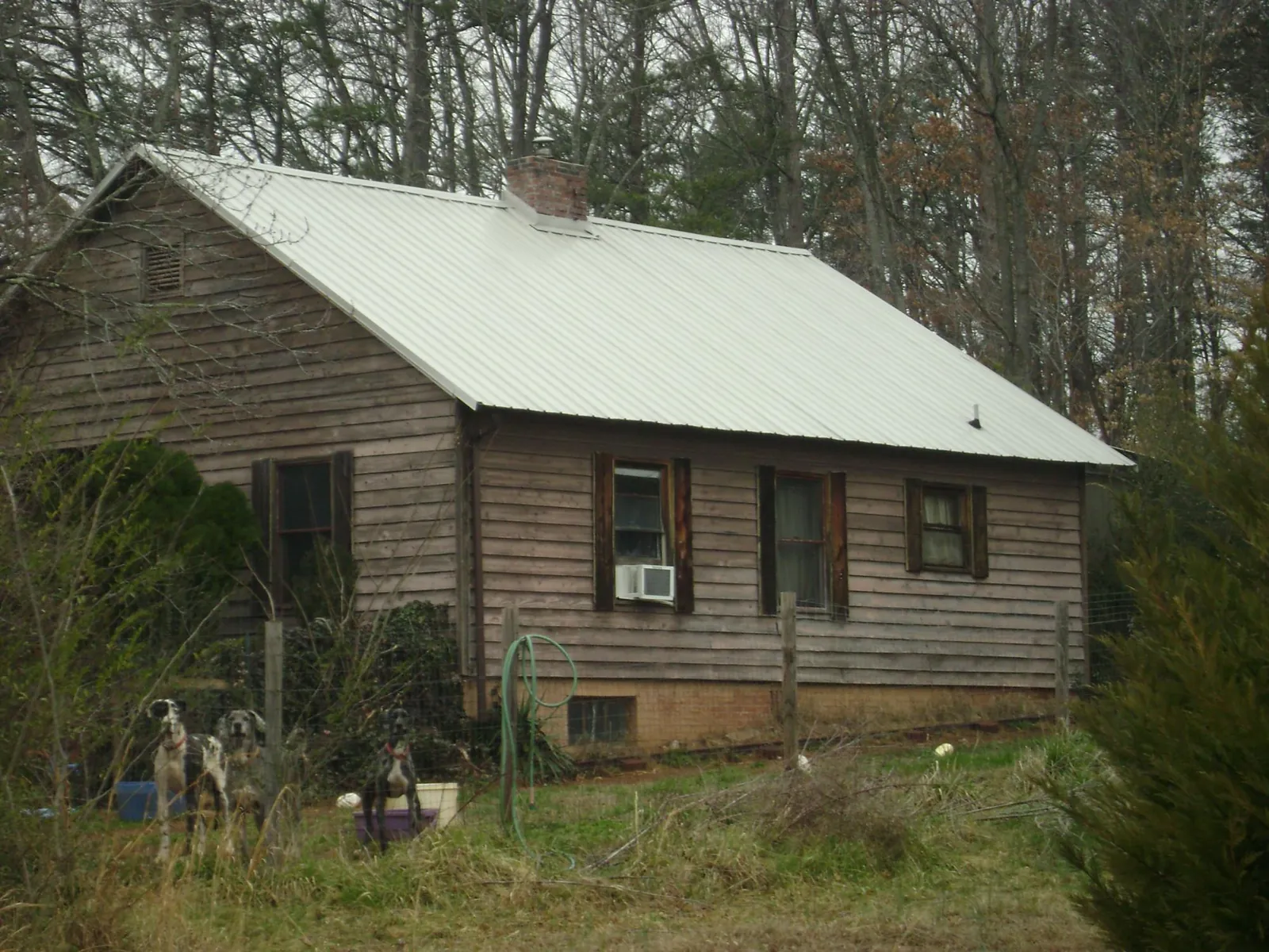 White metal roof on an old wood sided farmhouse, from a Metal Roof Installation job in Bend
